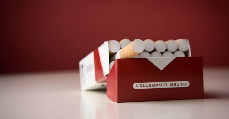 an open pack of cigarettes sits on a table | Kendall PC